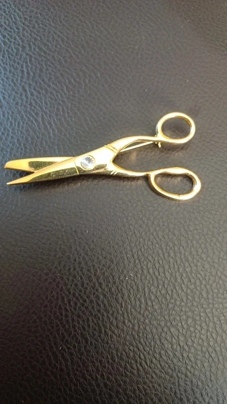 Broche ciseaux dorée neuve avec un strass